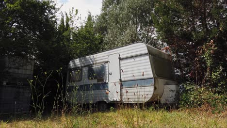 old disused and neglected caravan sits isolated surrounded by vegetation