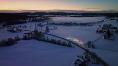 snowy landscape at dusk with roads and scattered houses, near sidensjö, sweden, aerial view