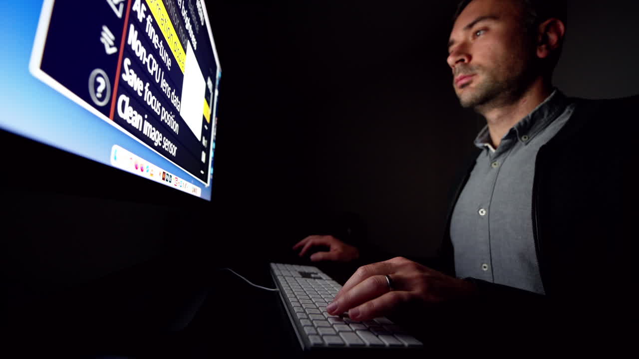 CHISINAU, MOLDOVA - NOVEMBER, 2021: Man working on iMac computer at night, dark room