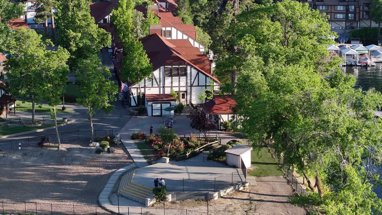 escenario de actuación de la aldea de la punta de flecha del lago durante la puesta de sol toneladas de luz creativa elevación aérea inclinación hacia abajo compresión de teleobjetivo