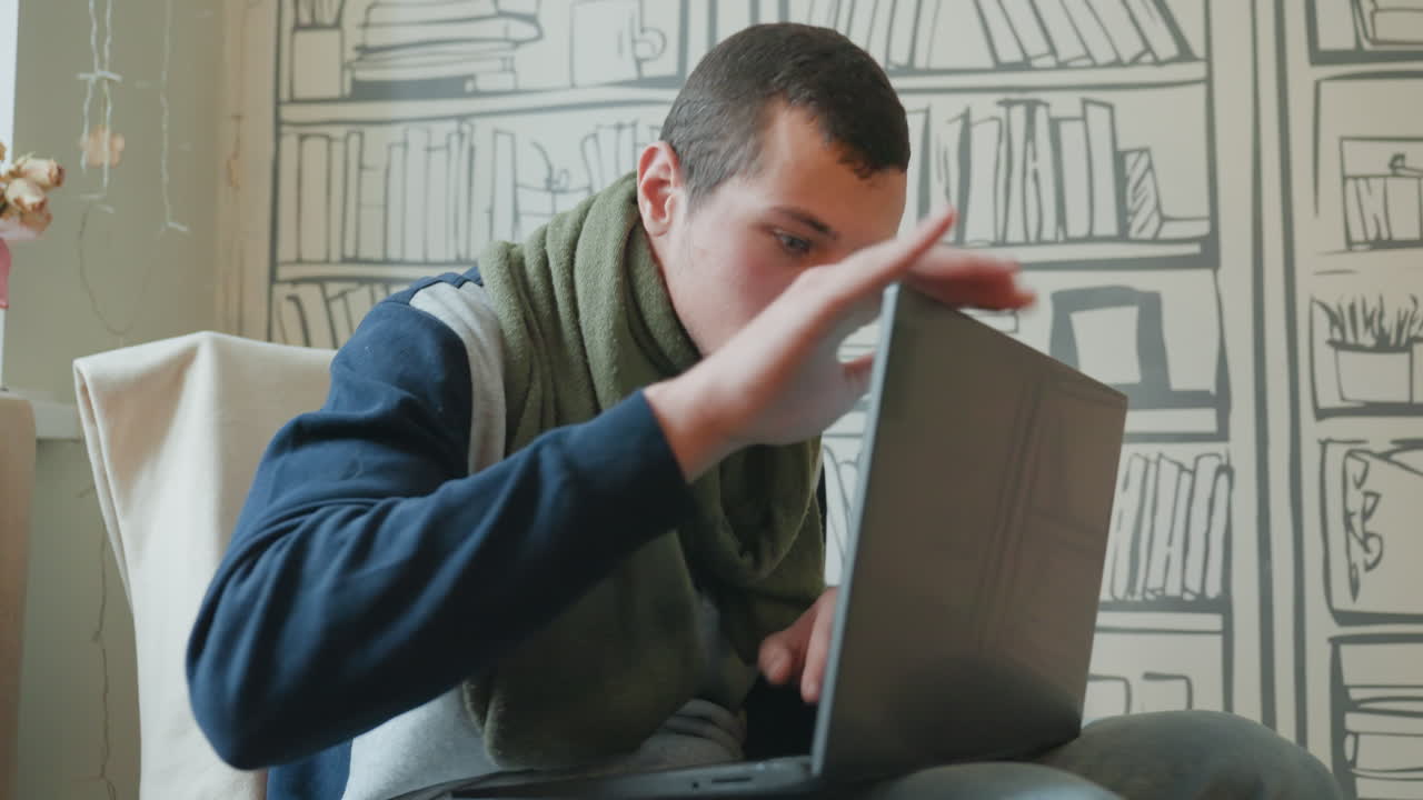 Caucasian man frustrated with laptop, hobbyist confronts malfunctioning hinge and glitching screen in cozy room with patterned bookshelf wall tense gestures, careful inspection with hands