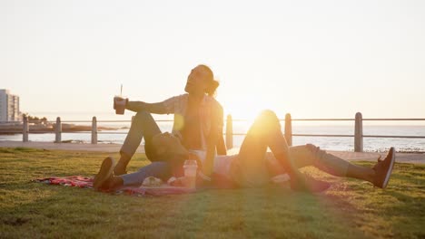 happy diverse gay male couple having picnic at promenade by the sea, slow motion