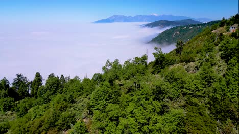 beautiful panoramic birds-eye-view over mountain, gliding towards an ocean of clouds in lake arrowhead on a gorgeous, summers day