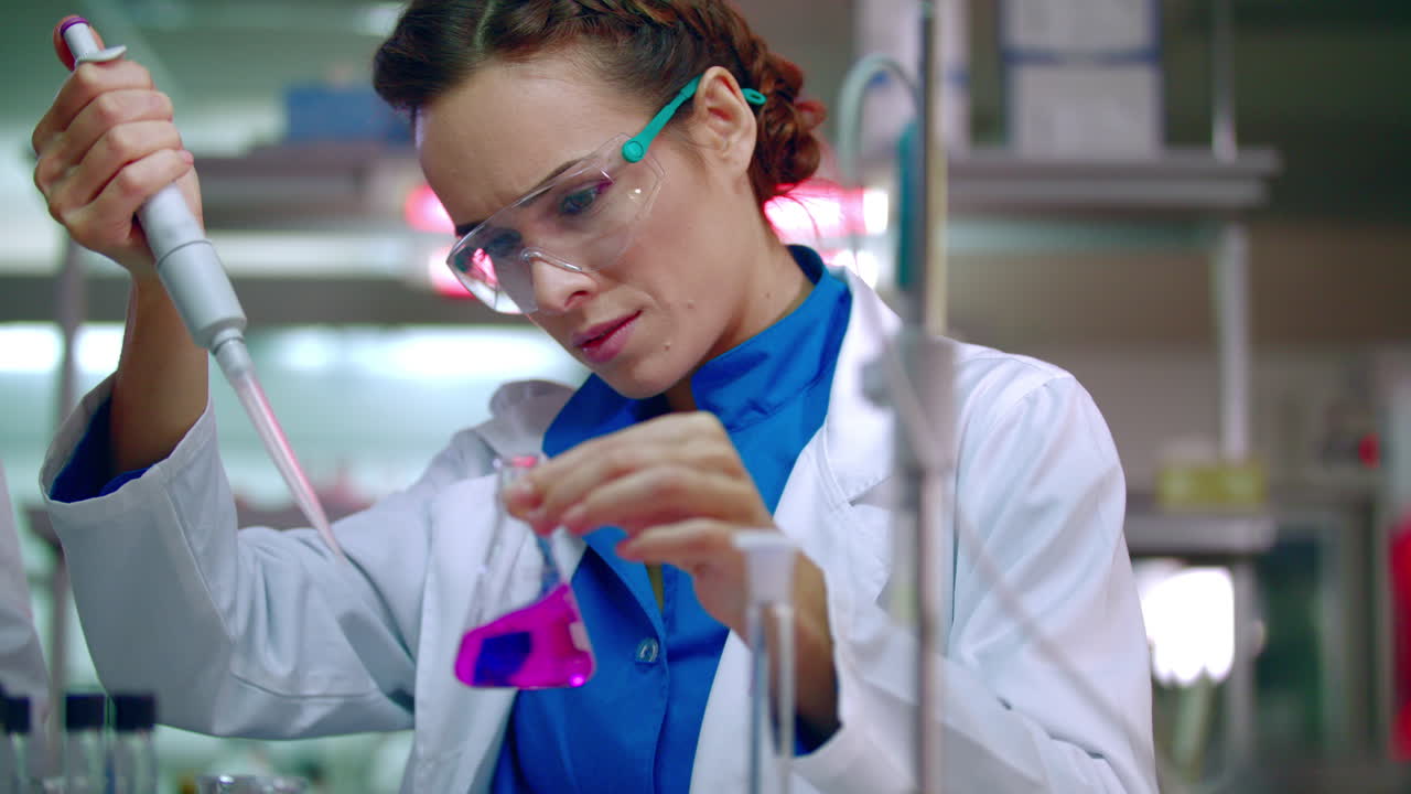 Lab worker dripping reagent in lab flask with liquid. Science experiment fail
