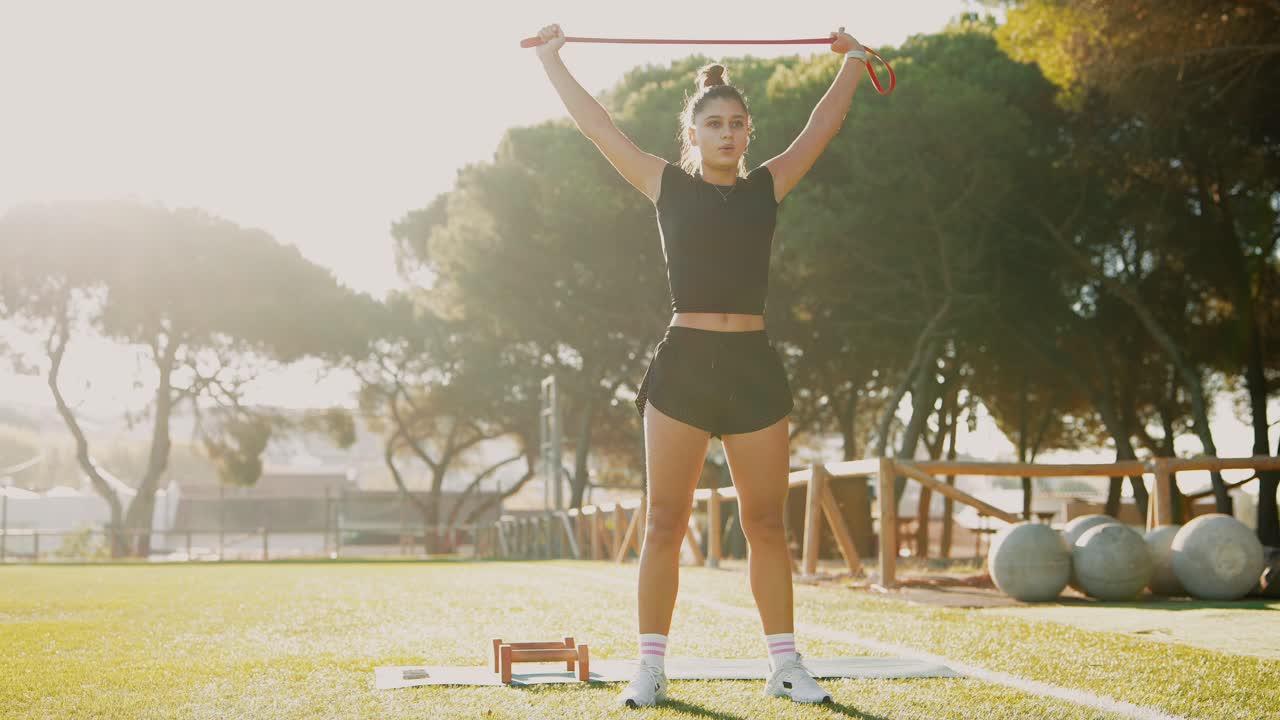 mujer haciendo ejercicio al aire libre con banda de resistencia