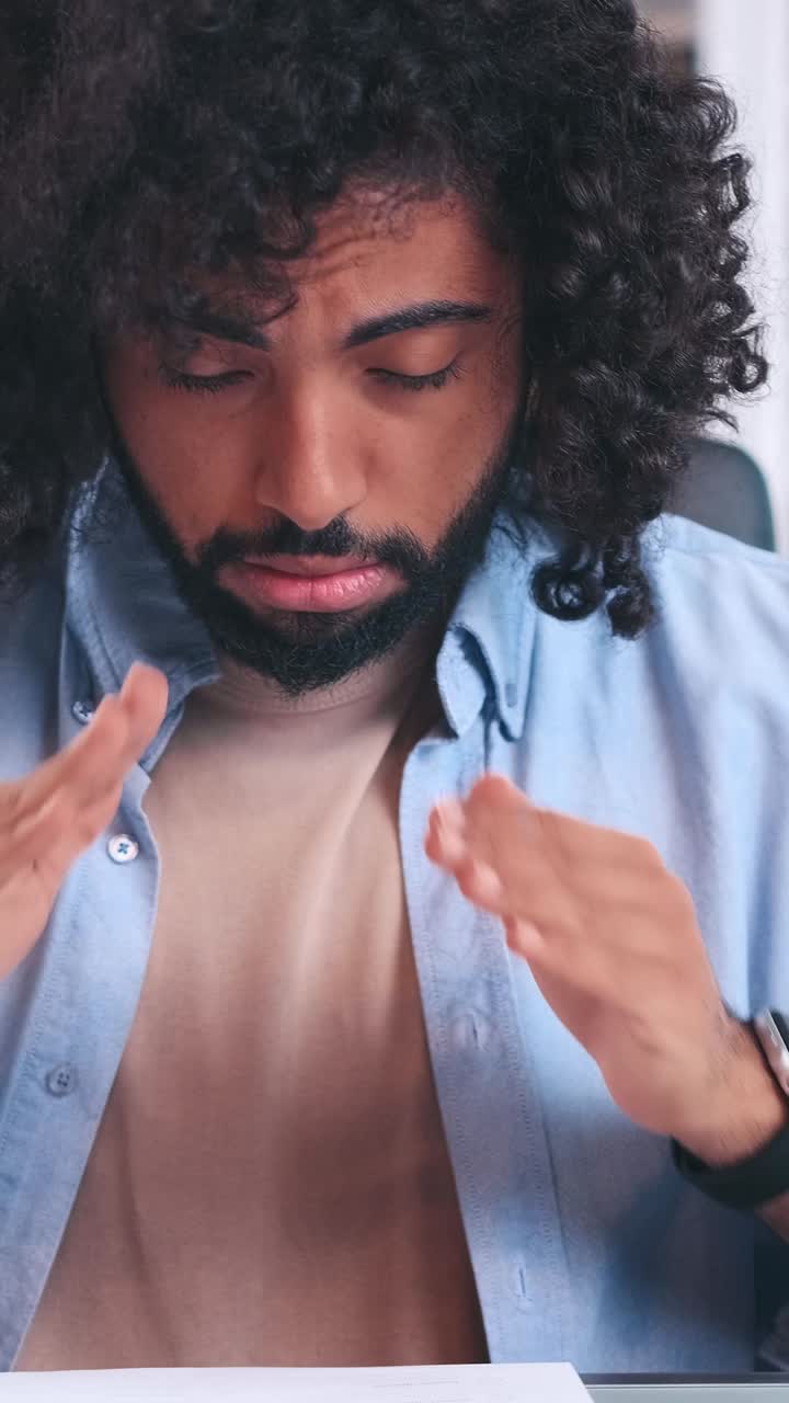 A man struggles with stress while working at his desk in a cozy office