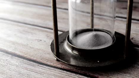 vintage hourglass on wooden table