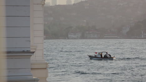 barco a motor com bandeira turca navegando no ondulado mar de mármara de istambul bósforo entre continentes na hora do pôr do sol