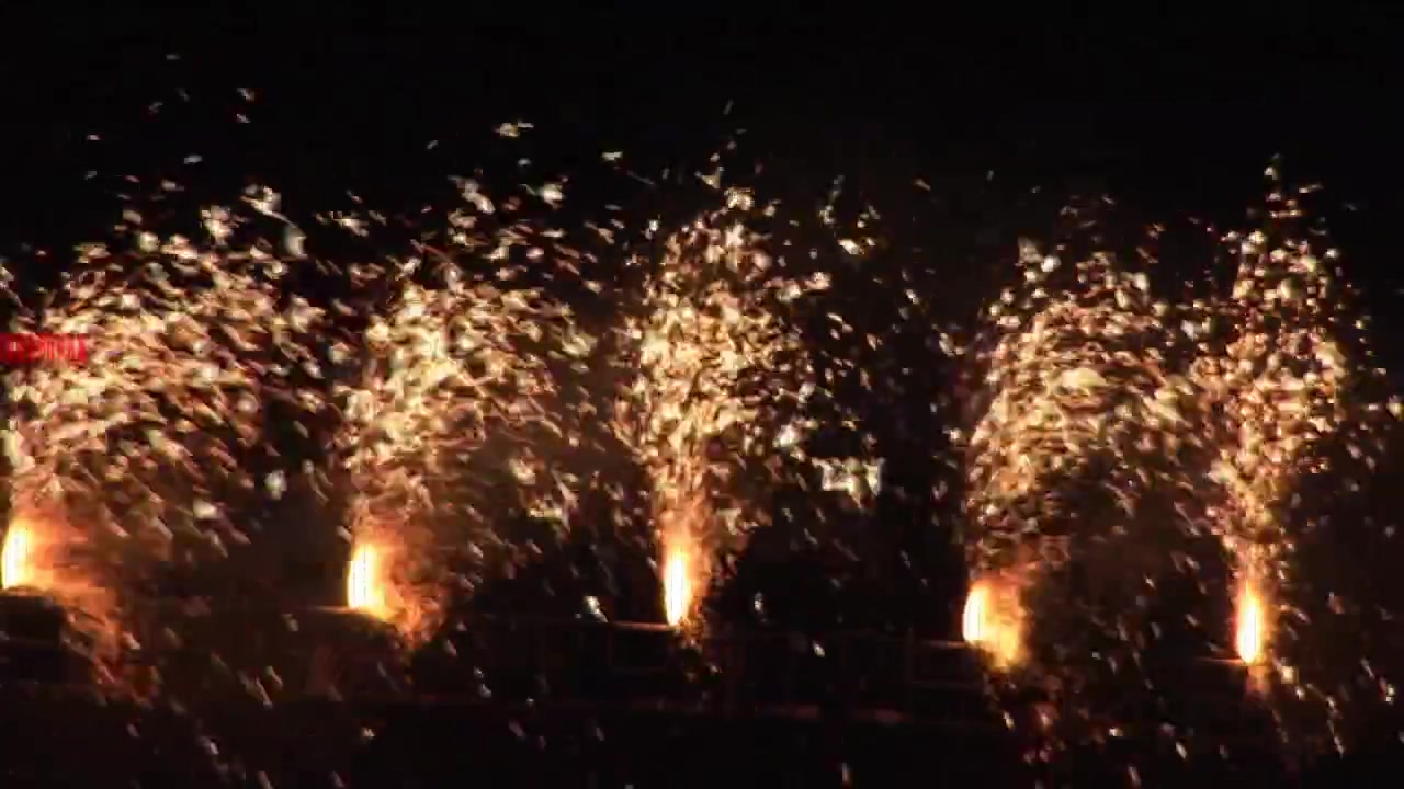 Animazione di effetto glitch su fuochi d'artificio dorati che esplodono su sfondo nero.