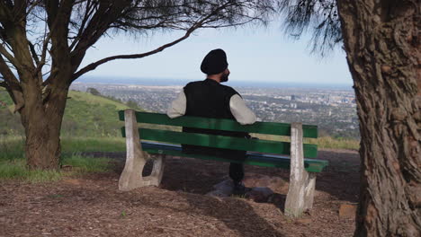 indian sikh man sitting on a bench and looking at scenic view - static shot