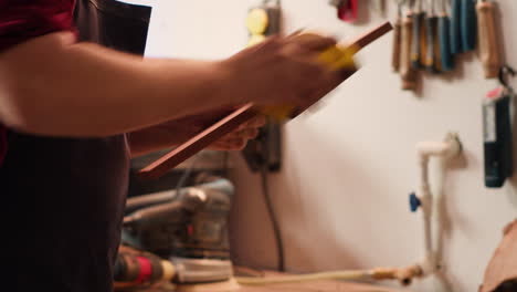 carpenter doing woodworking sandering on lumber block, fixing damages