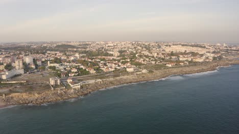 Luftdrohnenansicht-Mit-Blick-Auf-Das-Stadtbild-Von-Estoril,-Sonnenuntergangshimmelhorizont-In-Lissabon