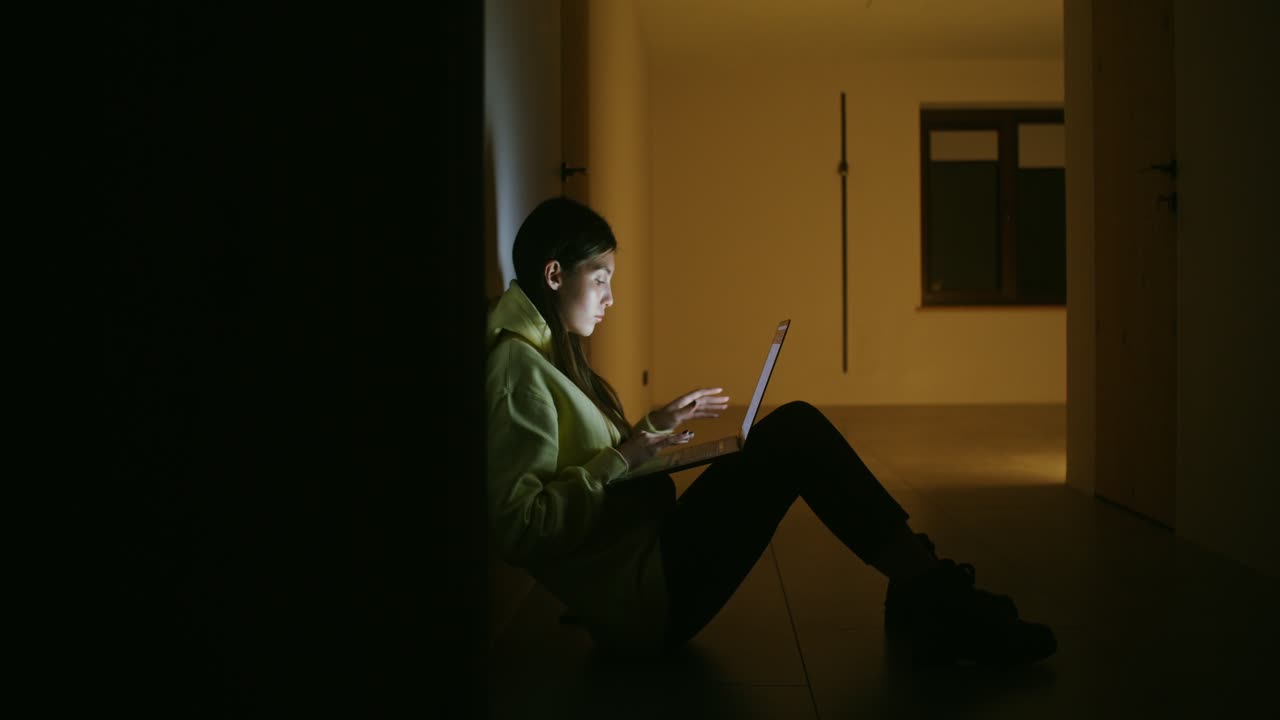 Woman working on laptop at night