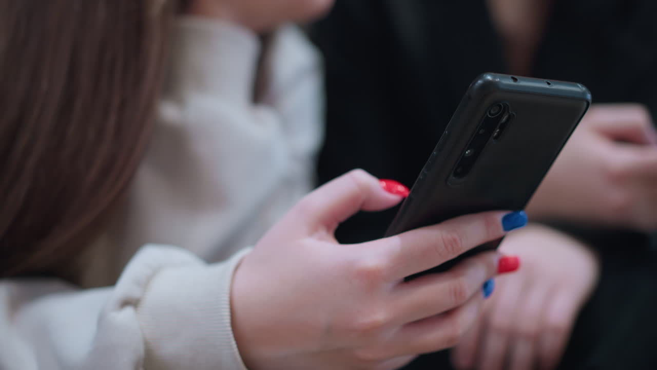 Close up partial view of people operating phones indoors focus on hand details modern lifestyle technology usage digital connection and communication concept with blurred background