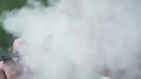 close up of male model smoking vaporizer outside slow motion