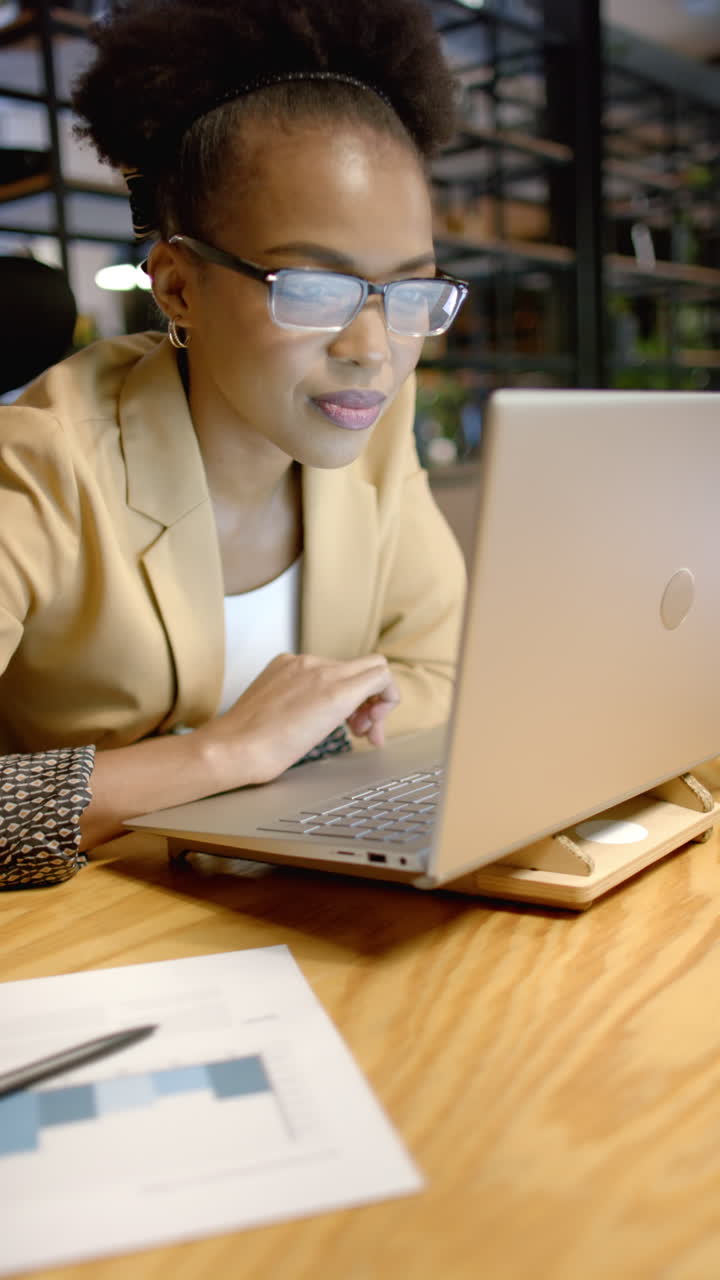 Vertical video: Working late, female business professional using laptop at office desk