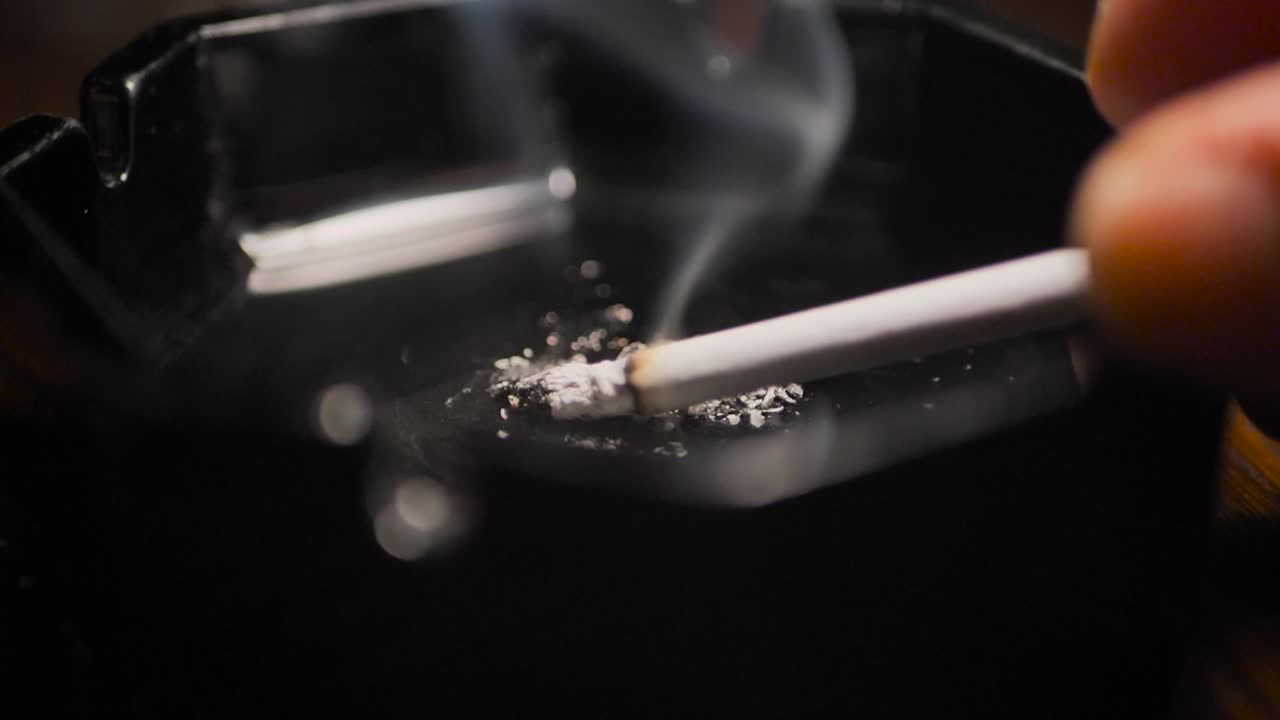 Close up smoking cigarette on man hand. Slowmotion. Scene H