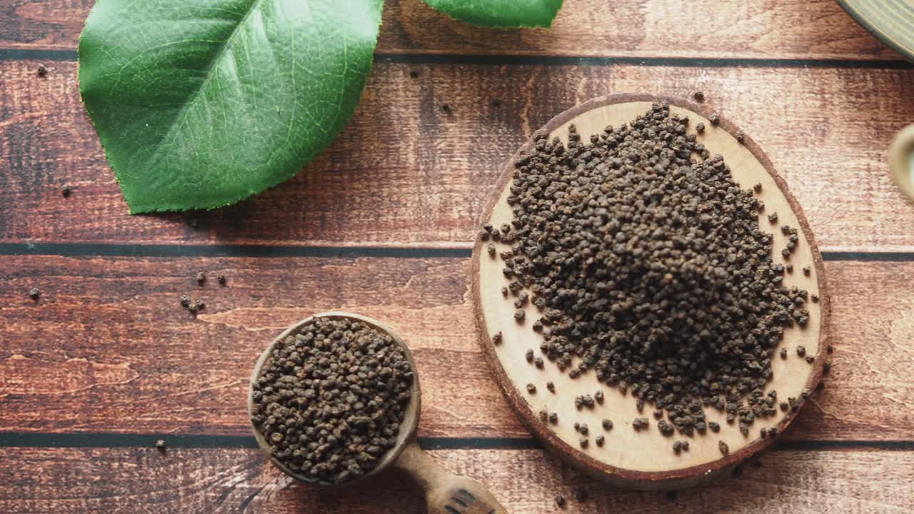 Tè nero sfuso su sottobicchiere di legno
