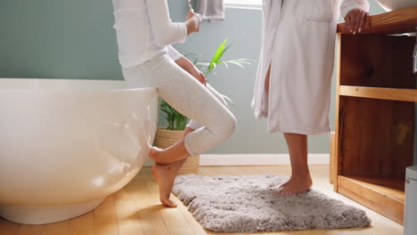 mother and daughter brushing teeth in bathroom