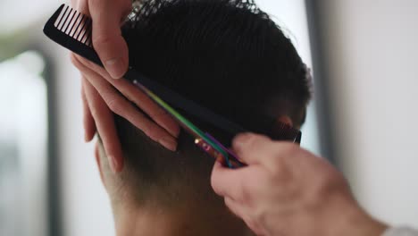 handheld view of man has cutting hair at the hairdresser