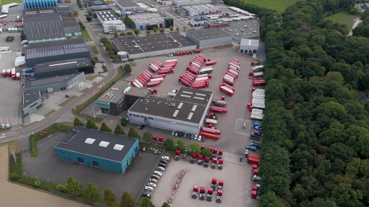 Aerial footage of a logistics center filled with red trucks and warehouses, symbolizing transport, commerce, and supply chain distribution