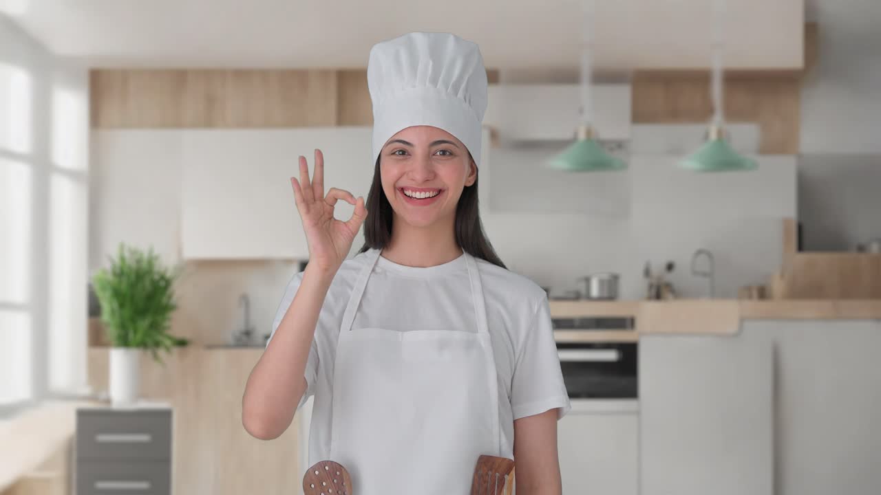 una mujer india feliz chef profesional mostrando un signo de bien
