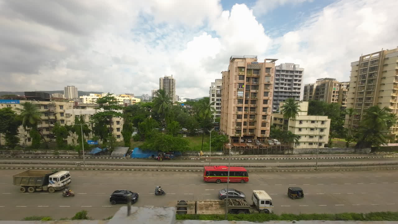 Bel tempo con vista sulla città dal tetto di un treno della metro, ripresa a volo d'uccello in movimento, India Mumbai Maharashtra