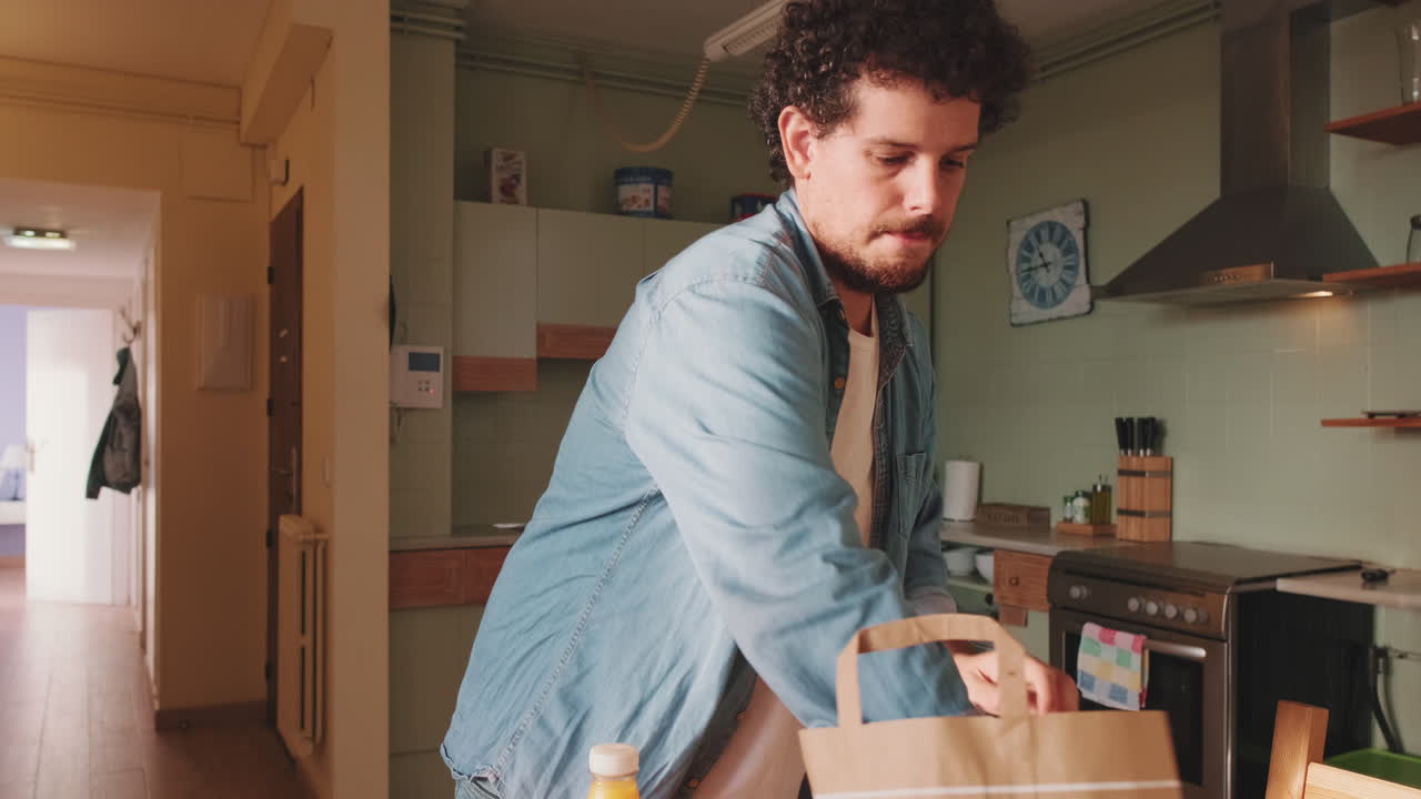 Uomo che sistema la spesa in cucina
