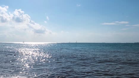 ocean scene with sailboats and clouds