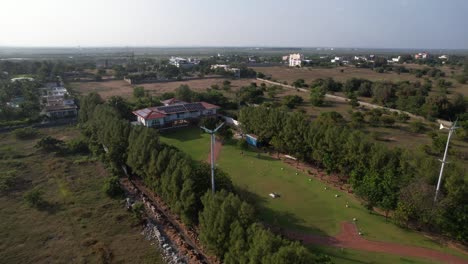 Aerial-Drone-Shot-of-Windmill-in-the-Middle-of-City-with-Green-Grass