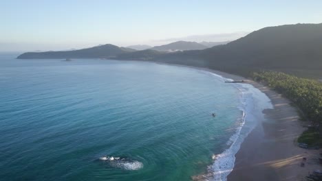 Aerial-tracking-shot-of-long-beautiful-Nacpan-Beach-near-El-Nido-at-sunset-on-Palawan,-the-Philippines