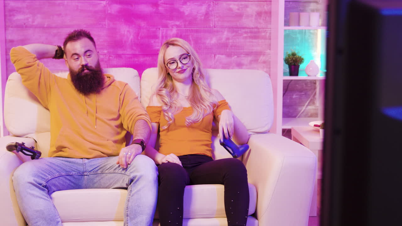 Pareja jugando a videojuegos en el sofá