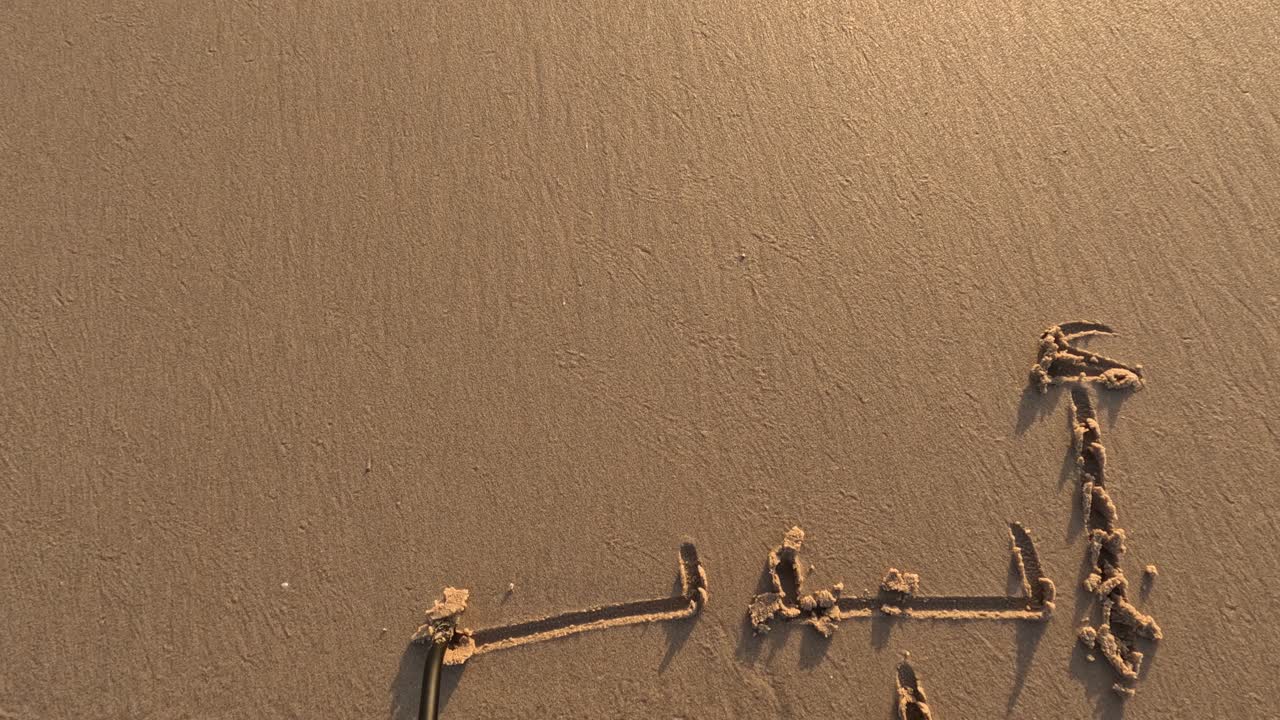 &ldquo;Alif Baa&rdquo; written by hand on beach sand,enjoying outdoor summer activities