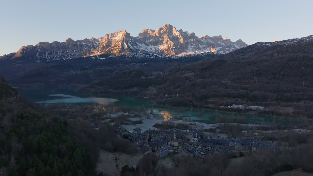 amanecer sobre una ciudad de montaña y un lago
