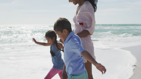 Sección-Media-De-Un-Feliz-Motor-Hispano-Con-Su-Hija-Y-Su-Hijo-Caminando-Por-La-Playa