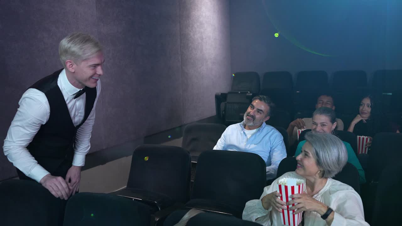 Pubblico in un cinema servito da un maschera