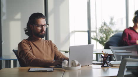 Mann-Aus-Dem-Nahen-Osten,-Der-Im-Büro-Am-Laptop-Arbeitet