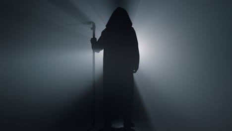 silhouette grim reaper standing indoors. death with scythe spotlight background.