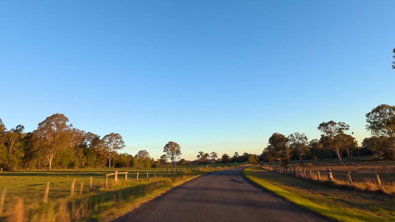 Uma perspectiva de direção em primeira pessoa ao longo de uma estrada rural tranquila em Maclean, Nova Gales do Sul