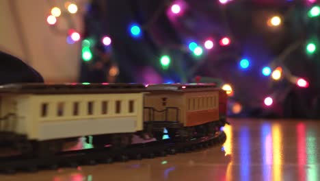 close up of toy train going around decorated christmas tree