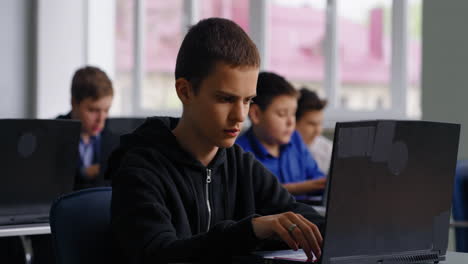 students working on laptops in a classroom