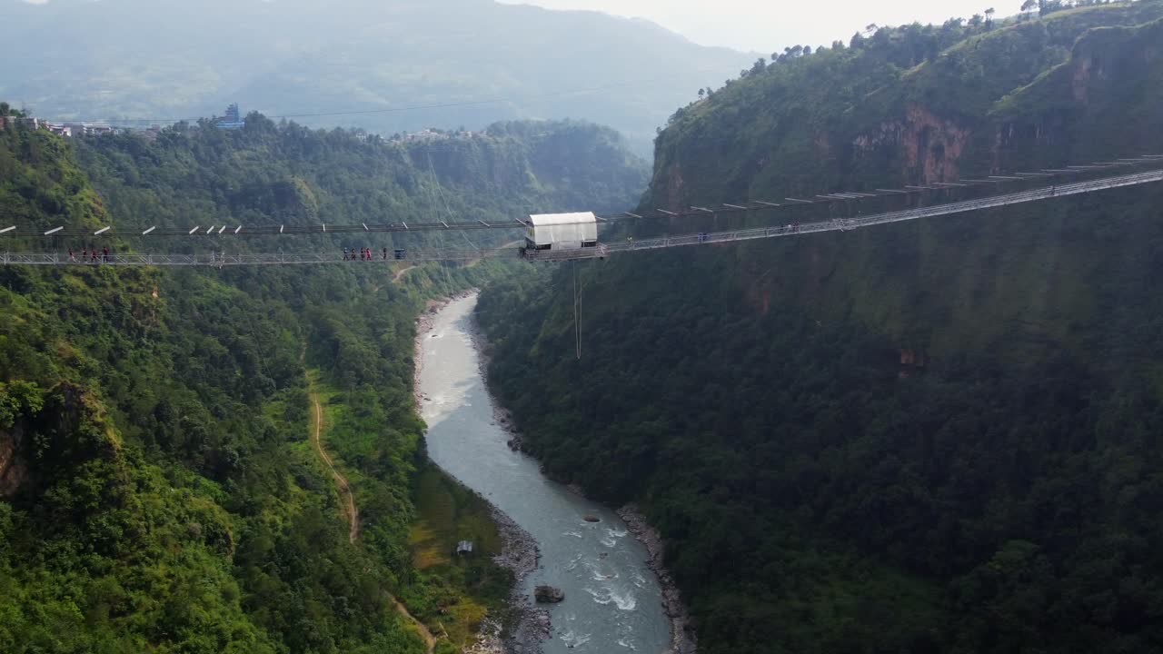 Bungee Jumping from bridge into valley of Nepal during sunny day, Aerial view
