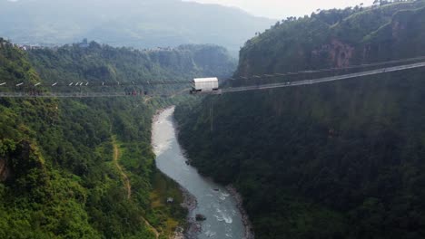 bungee jumping from bridge into valley of nepal during sunny day, aerial view
