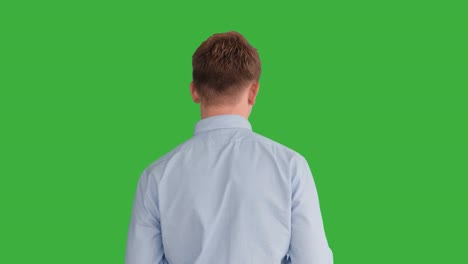 joven caucásico de pie contra el fondo de la pantalla verde. persona masculina aislada en la llave de croma. retrato profesional de negocios casual