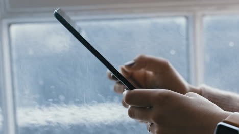 close-up-woman-hands-using-digital-tablet-computer-browsing-online-messages-reading-social-media-enjoying-mobile-touchscreen-device-standing-by-window-relaxing-at-home-on-cold-rainy-day