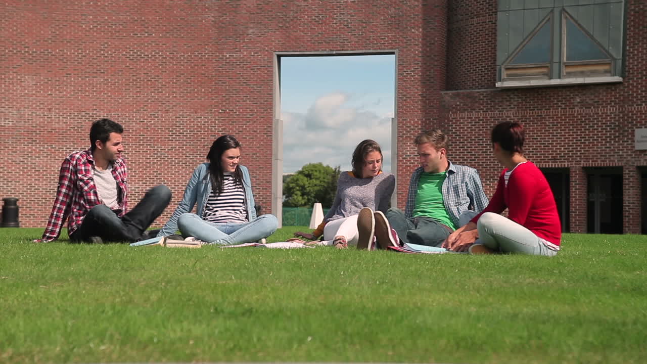 Studenter prater sammen mens de sitter ute