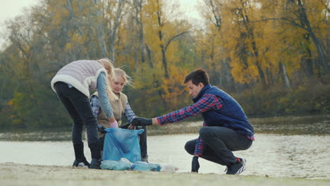 a woman with children picks up trash on the lake volunteers collect plastic waste