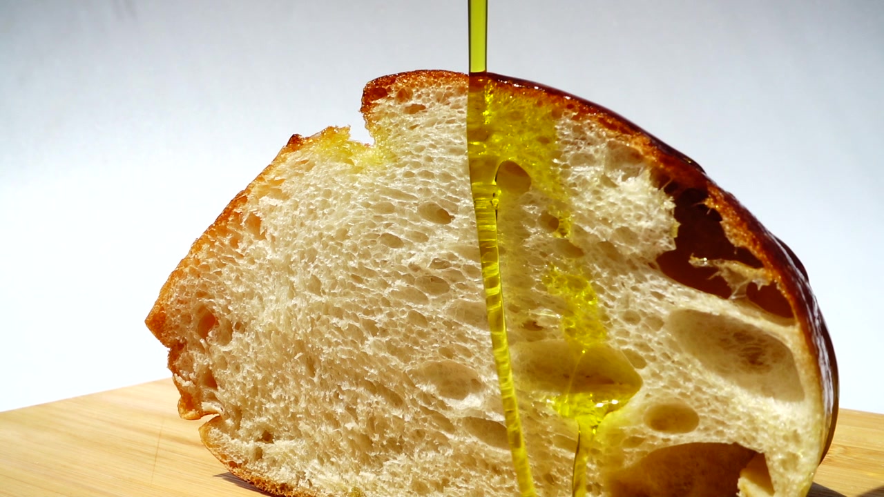 Olio d'oliva versato su un pezzo di pane