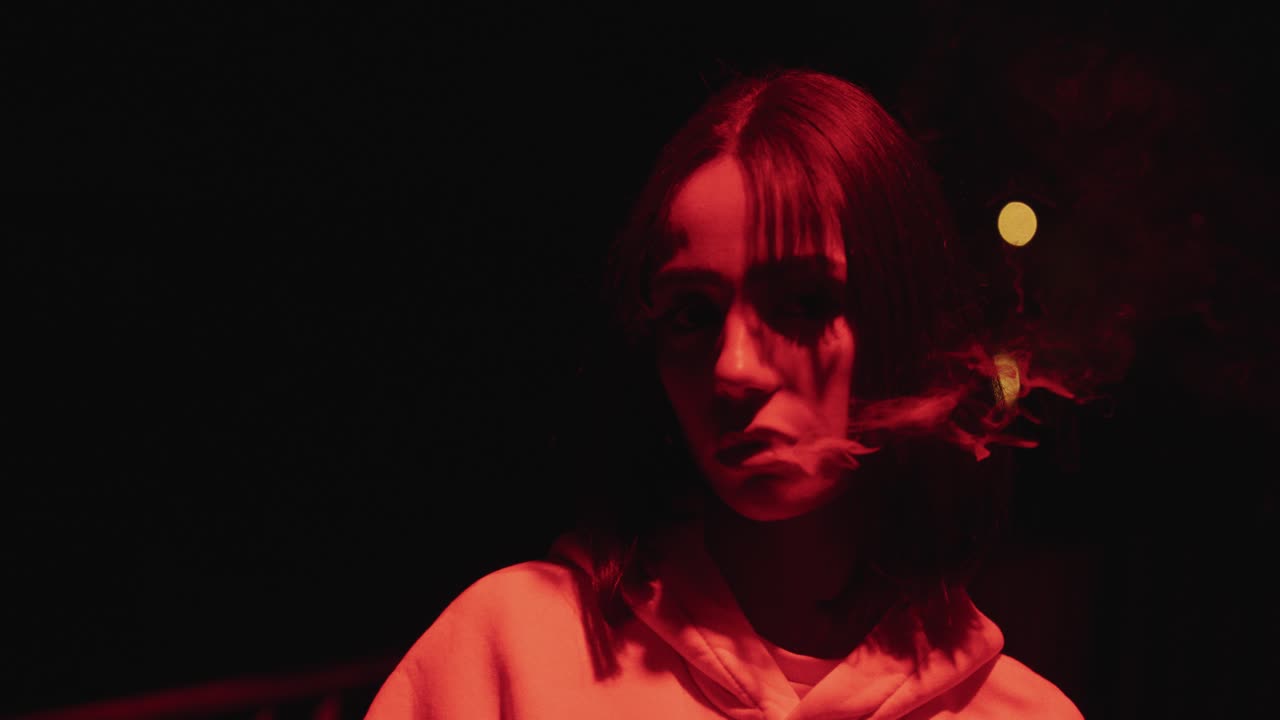 young woman smoking in red light with slow motion