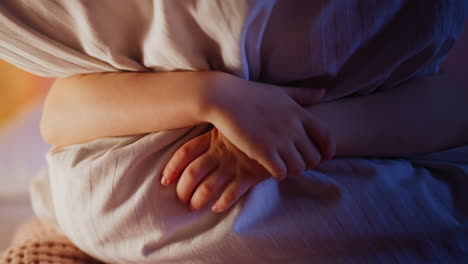 little kid hugs huge soft striped pillow in semidark bedroom